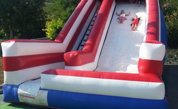 Structure gonflable de jeu en plein air : les enfants glissent dans le toboggan